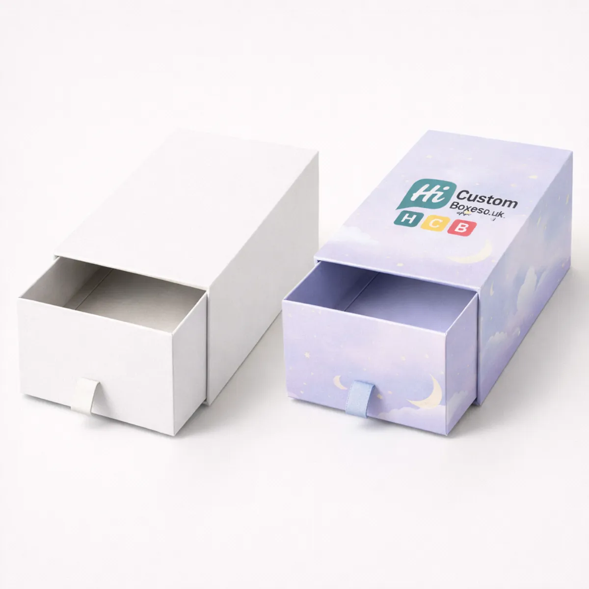 Two sliding drawer boxes- one plain white and one lilac with a celestial night-sky pattern- class=